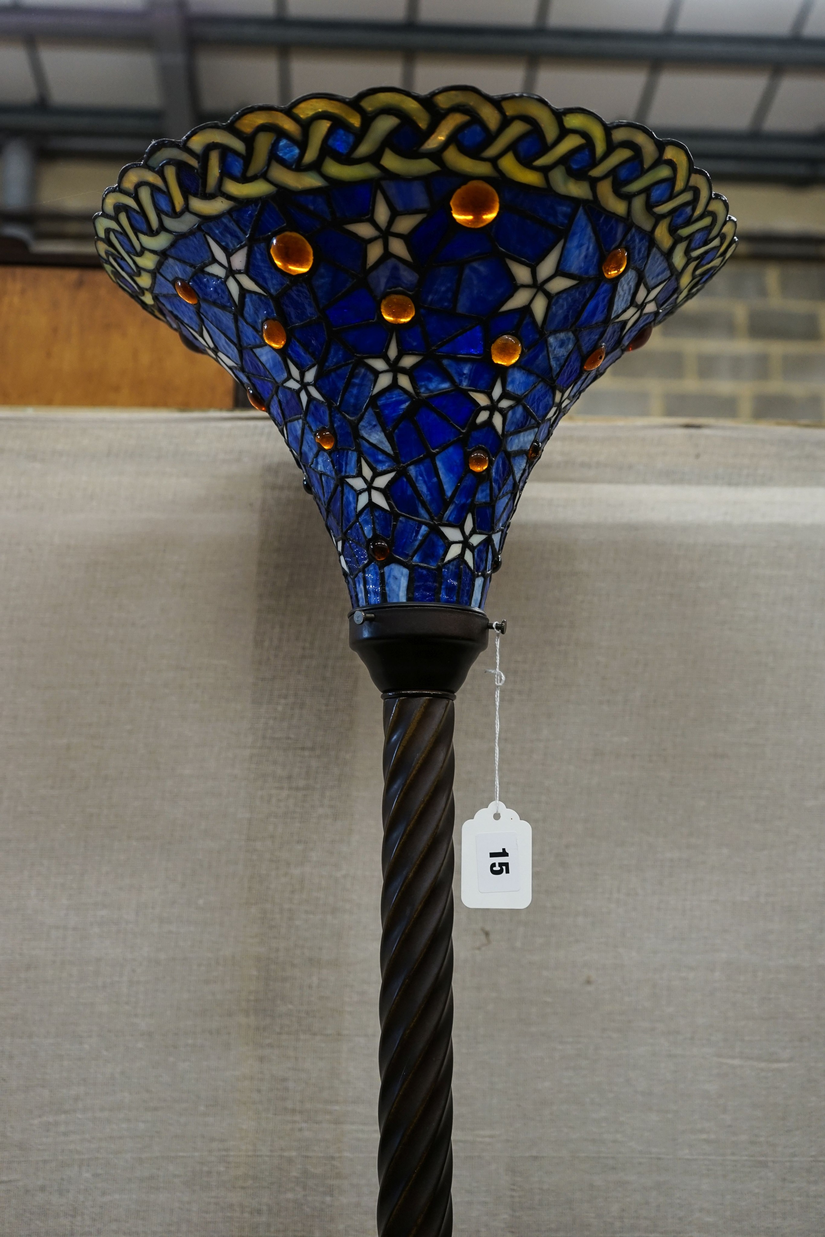 A bronzed finish Tiffany style uplighter floor lamp with flared blue leaded shade, 187cm high, 36cm diameter